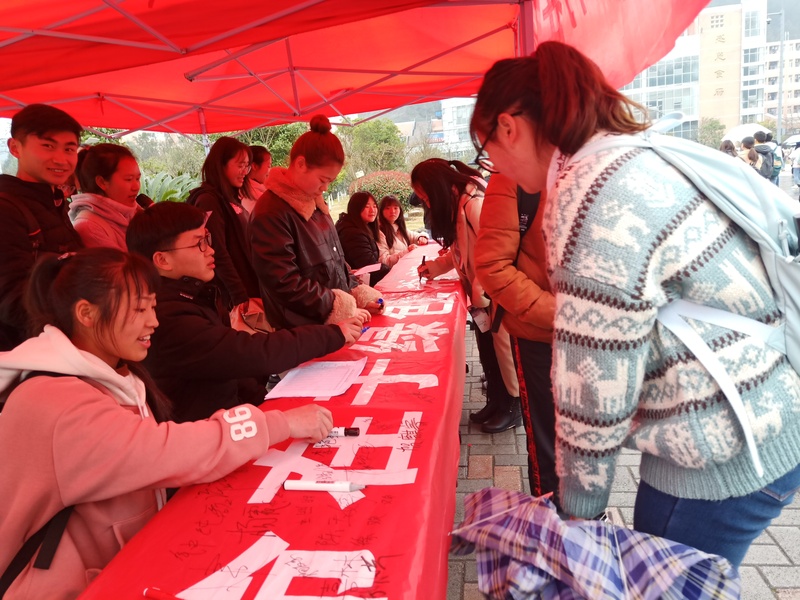 1员工会成员在向签名同学宣传植树活动.jpg